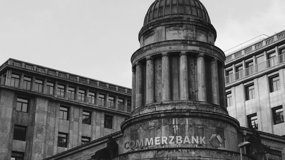 Historic Commerzbank building with neoclassical architecture, featuring a large dome and columns. Black and white image.