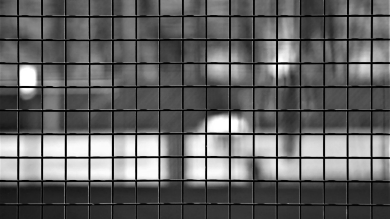 A blurred black-and-white image of a grid pattern with a defocused background.