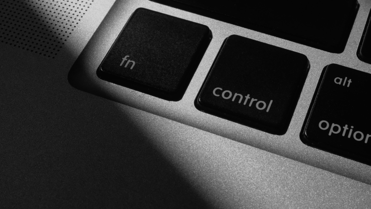 Close-up of a laptop keyboard showing the "fn" and "control" keys in monochrome lighting.